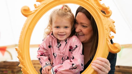 A mum and her daughter laugh and play in the Summer of Play tent in Saltram's garden
